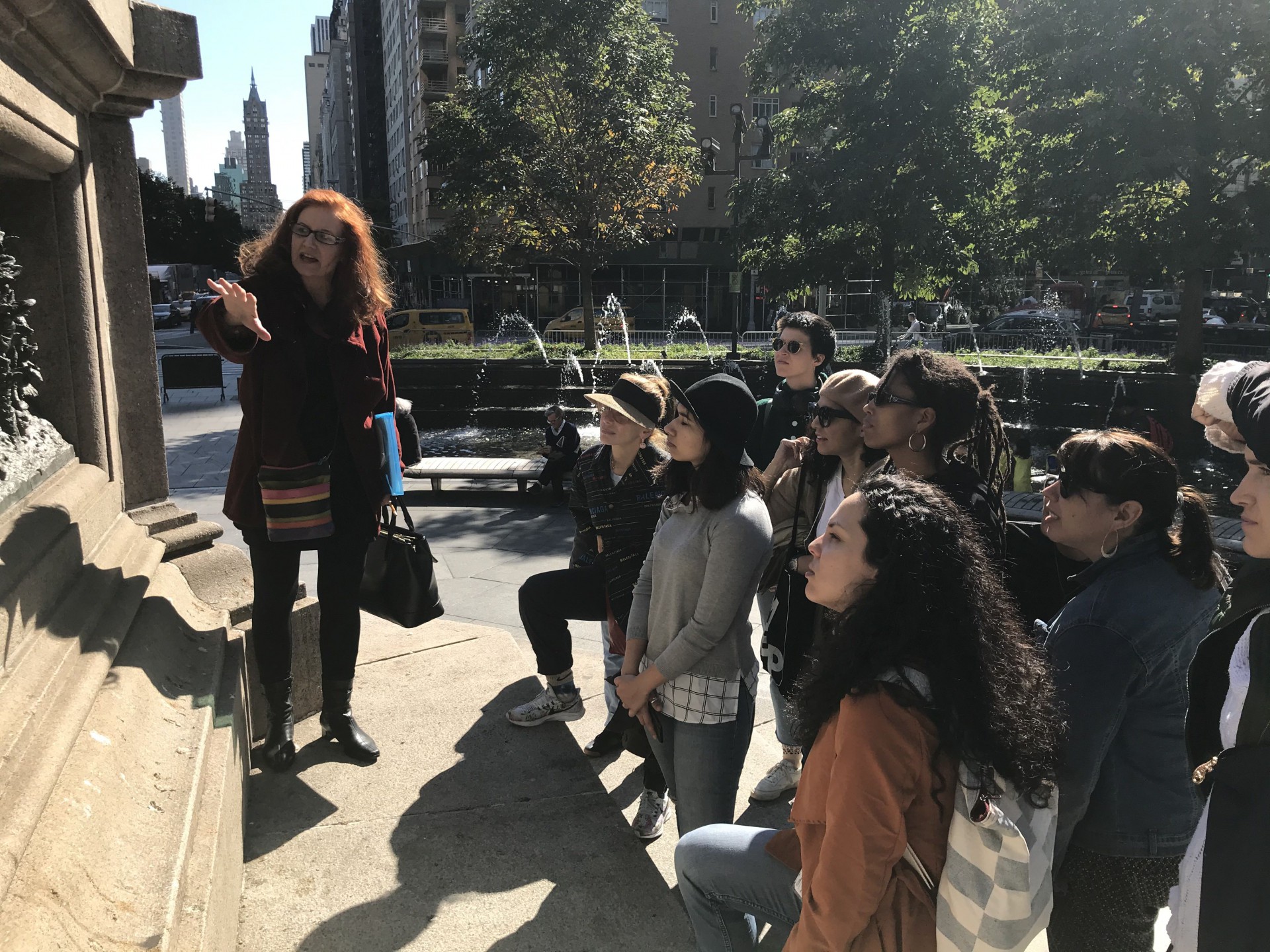 Image of Professor Karen Finley in front of Columbus monument in Columbus Circle in front of group of Arts Politics students